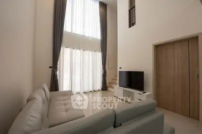 Spacious modern living room with high ceilings and large windows