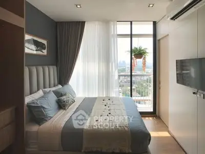 Modern bedroom with large window and city view, featuring stylish decor and natural light.