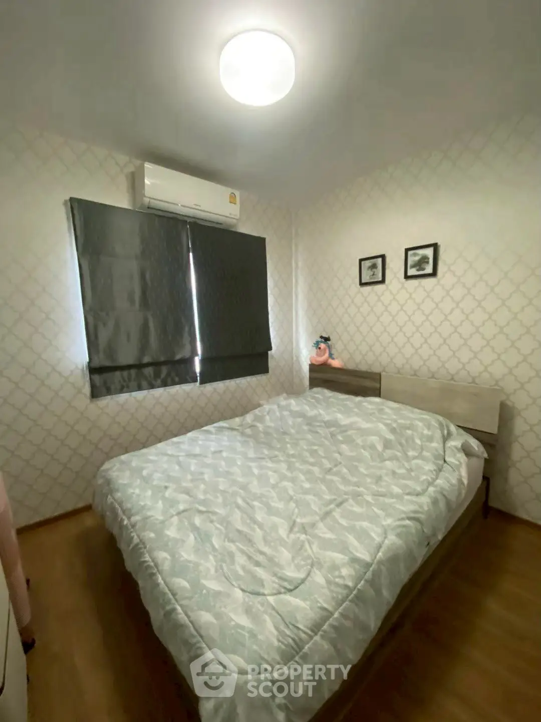 Cozy bedroom with modern decor and air conditioning, perfect for relaxation.