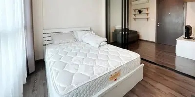 Modern bedroom with wooden flooring and sliding glass doors in a stylish apartment.