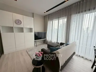 Modern living room with sleek furniture and large windows offering city views.