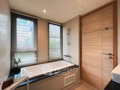 Modern bathroom with large windows and sleek bathtub in luxury apartment