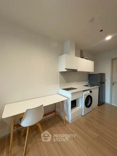 Modern compact kitchen with washing machine and sleek white cabinetry