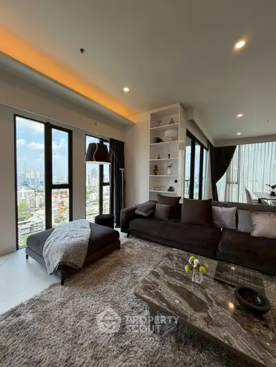 Luxurious living room with panoramic city views, modern decor, and plush furnishings in a high-rise apartment.