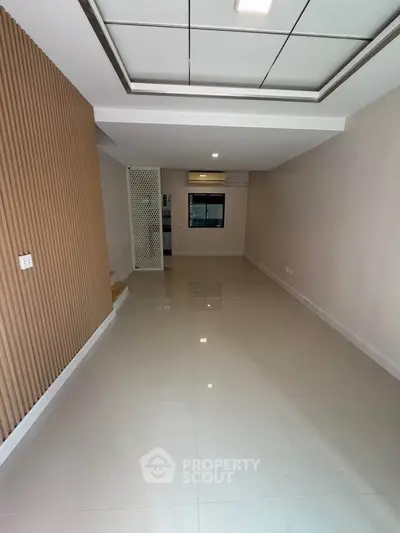 Spacious modern living room with sleek flooring and stylish wall paneling