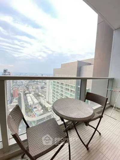 Stunning high-rise balcony with panoramic city views and cozy outdoor seating.