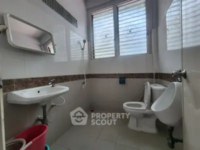 Spacious bathroom with modern fixtures and natural light from large windows.