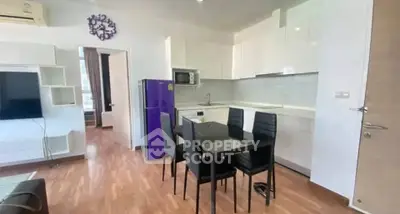 Modern open-layout kitchen with dining area and sleek appliances in a stylish apartment.