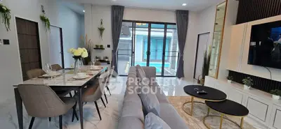 Luxurious living room with pool view, elegant dining setup, and modern decor.