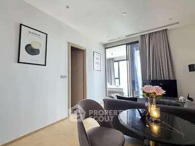 Modern living room with elegant decor and natural light, featuring a cozy seating area and stylish dining space.