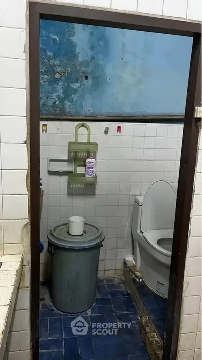Compact bathroom with basic amenities and blue tiled floor.