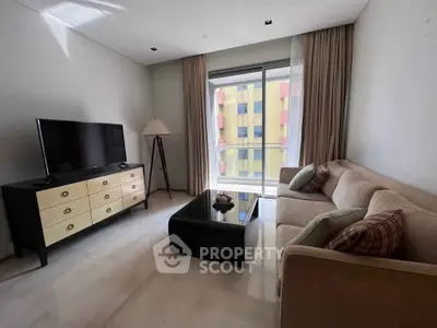 Modern living room with stylish furniture and large window offering natural light.