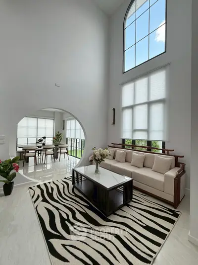 Stunning modern living room with high ceilings and large windows, featuring elegant decor and natural light.