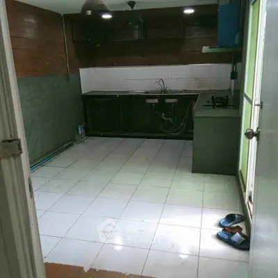 Spacious kitchen with tiled floor and wooden accents, ready for renovation.