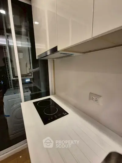 Modern kitchen with sleek induction cooktop and white cabinetry
