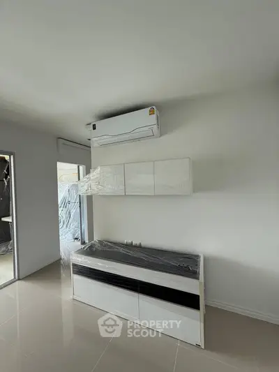 Modern kitchen with sleek cabinetry and air conditioning unit in a minimalist design.