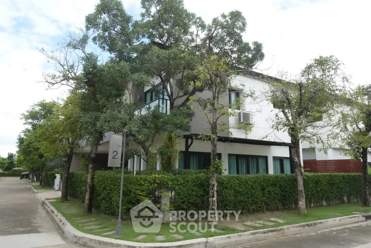 Modern two-story house with lush greenery and a well-maintained garden in a serene neighborhood.