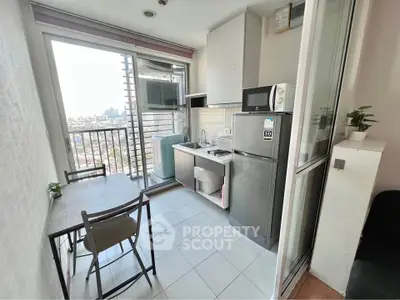 Charming compact kitchen with city view, featuring modern appliances and cozy dining area.