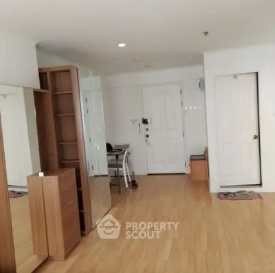 Spacious entryway with wooden flooring and modern furniture in a stylish apartment.