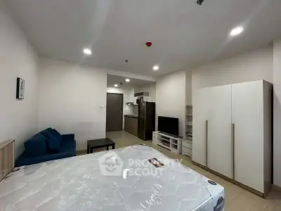 Modern studio apartment with open layout, featuring a cozy living area and compact kitchen.