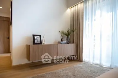 Modern living room with elegant wooden furniture and large window drapes.