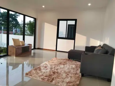 Spacious living room with modern furniture and large windows offering natural light.