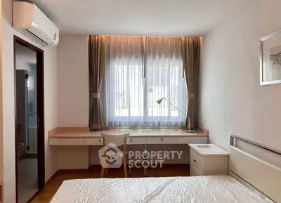 Bright and airy bedroom with modern furnishings and large window for natural light.