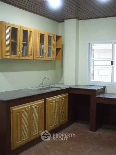 Spacious kitchen with wooden cabinets and granite countertops