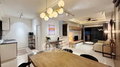 Modern open-plan living room with stylish decor and elegant lighting, featuring a cozy seating area and dining space.