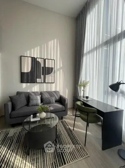 Modern living room with high ceilings, stylish furniture, and large windows for natural light.