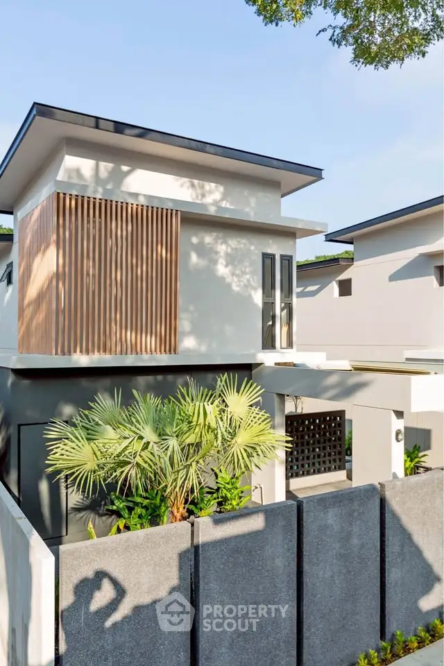 Modern two-story house with sleek design and lush greenery, perfect for contemporary living.