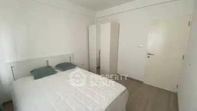 Cozy minimalist bedroom with white decor and wooden flooring