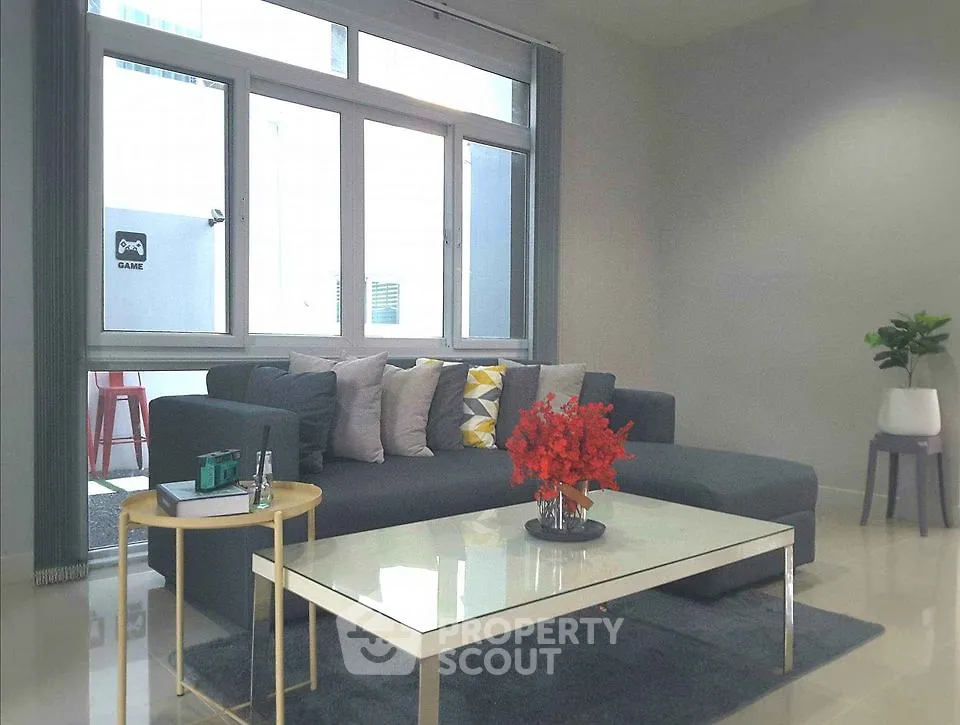 Modern living room with sleek sofa, large windows, and stylish decor