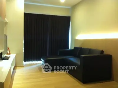 Modern living room with sleek black sofa and ambient lighting