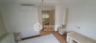 Spacious bedroom with ample natural light, featuring air conditioning and a cozy corner perfect for relaxation or reading.