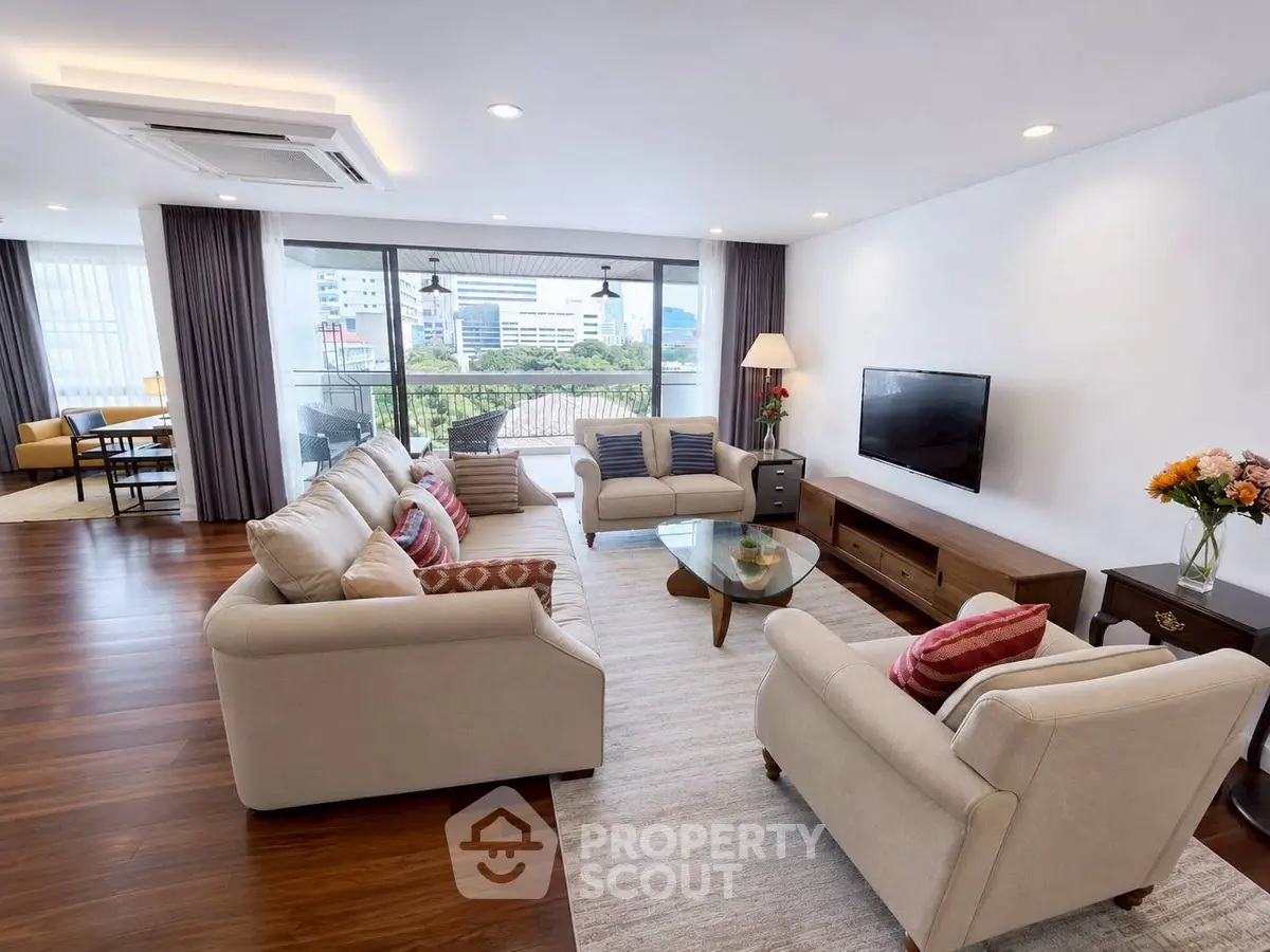 Spacious living room with modern decor and large windows offering city views.