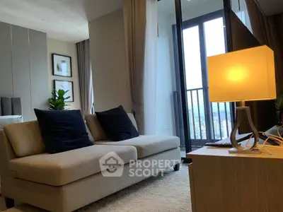 Modern living room with cozy sofa and elegant lamp near balcony with city view.