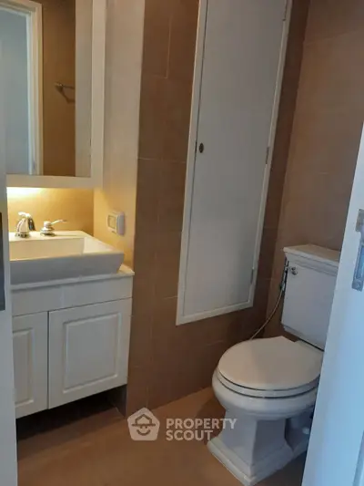 Compact bathroom with modern fixtures and storage cabinet, ideal for efficient space utilization.