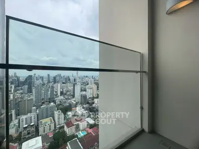 Stunning cityscape view from a modern high-rise balcony with glass railing.