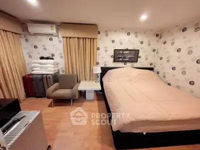 Cozy bedroom with stylish wallpaper and modern furnishings in a well-lit space.