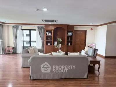 Spacious living room with elegant wooden flooring and cozy seating area, perfect for relaxation and entertainment.