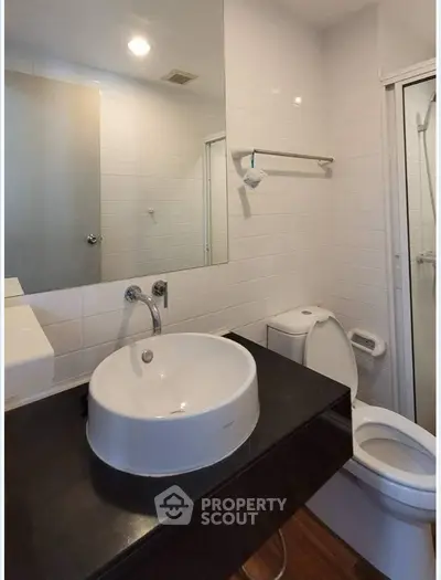Modern bathroom with sleek fixtures and large mirror in a contemporary home.