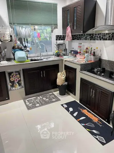 Cozy kitchen with closed layout and gas stove, featuring modern cabinetry and ample natural light.