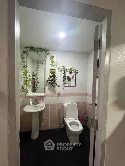 Charming bathroom with modern fixtures and decorative greenery accents.