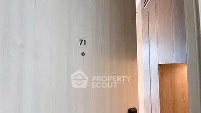 Modern apartment entrance with sleek wooden door and room number 71.