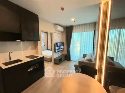 Modern open-plan living room with sleek kitchen and cozy seating area