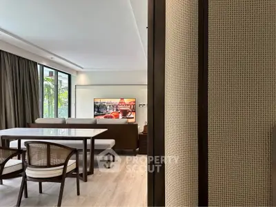 Elegant living room with modern dining area and large windows offering natural light.