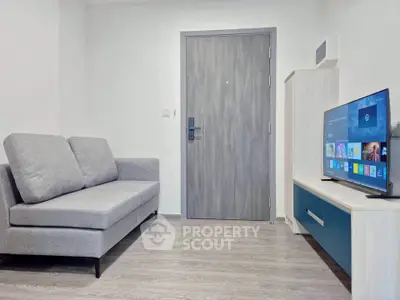 Modern living room with sleek sofa and flat-screen TV, perfect for cozy relaxation.