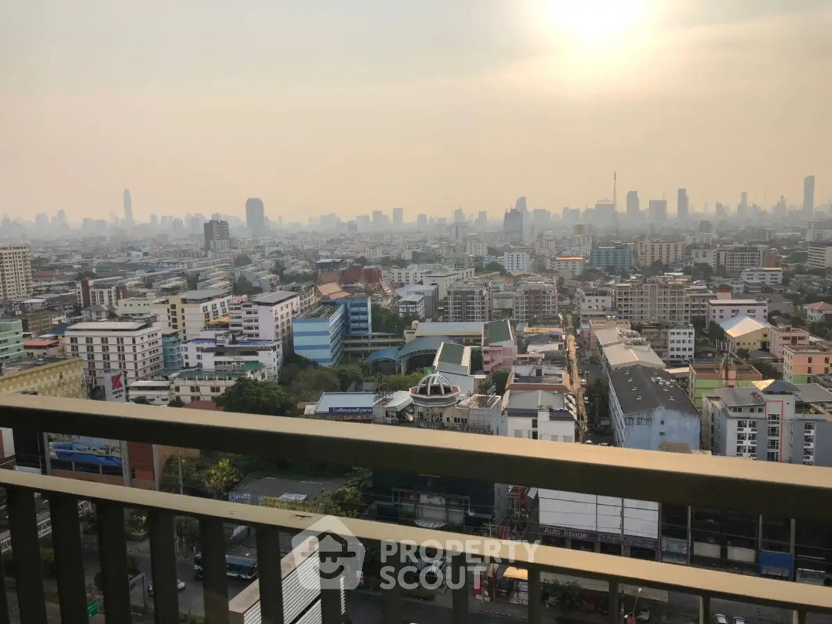 Stunning cityscape view from high-rise balcony with urban skyline at sunset.