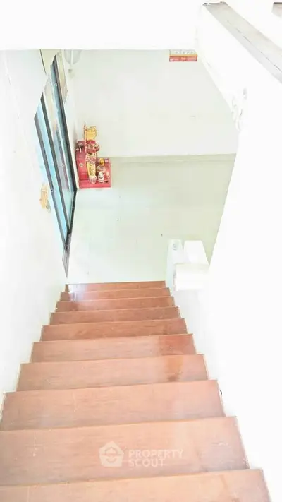 Spacious interior stairway leading to a bright room with sliding glass doors.